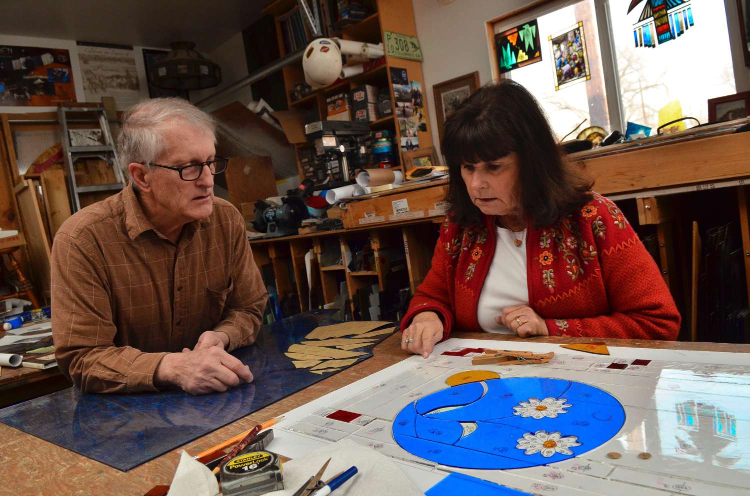 Phil and Jane Watkins reviewing a stained glass design in their studio