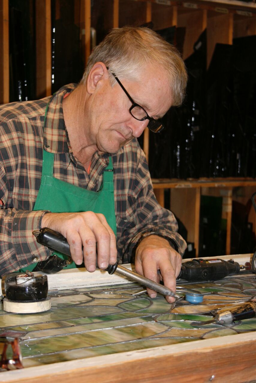 Phil Watkins soldering a stained glass panel by hand